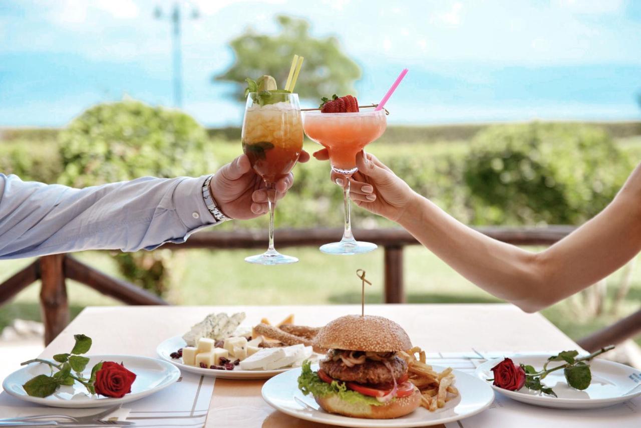 Mitsis Galini Hotel Kamena Vourla Ngoại thất bức ảnh A couple toasting with cocktails